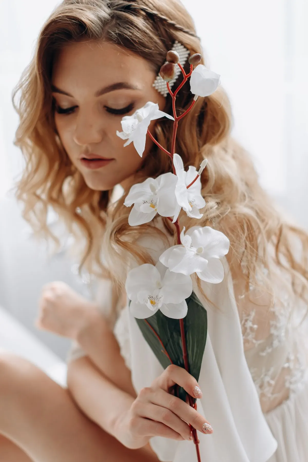 Loose wavy western-style hairstyle accented with a pearl hairpin and florals