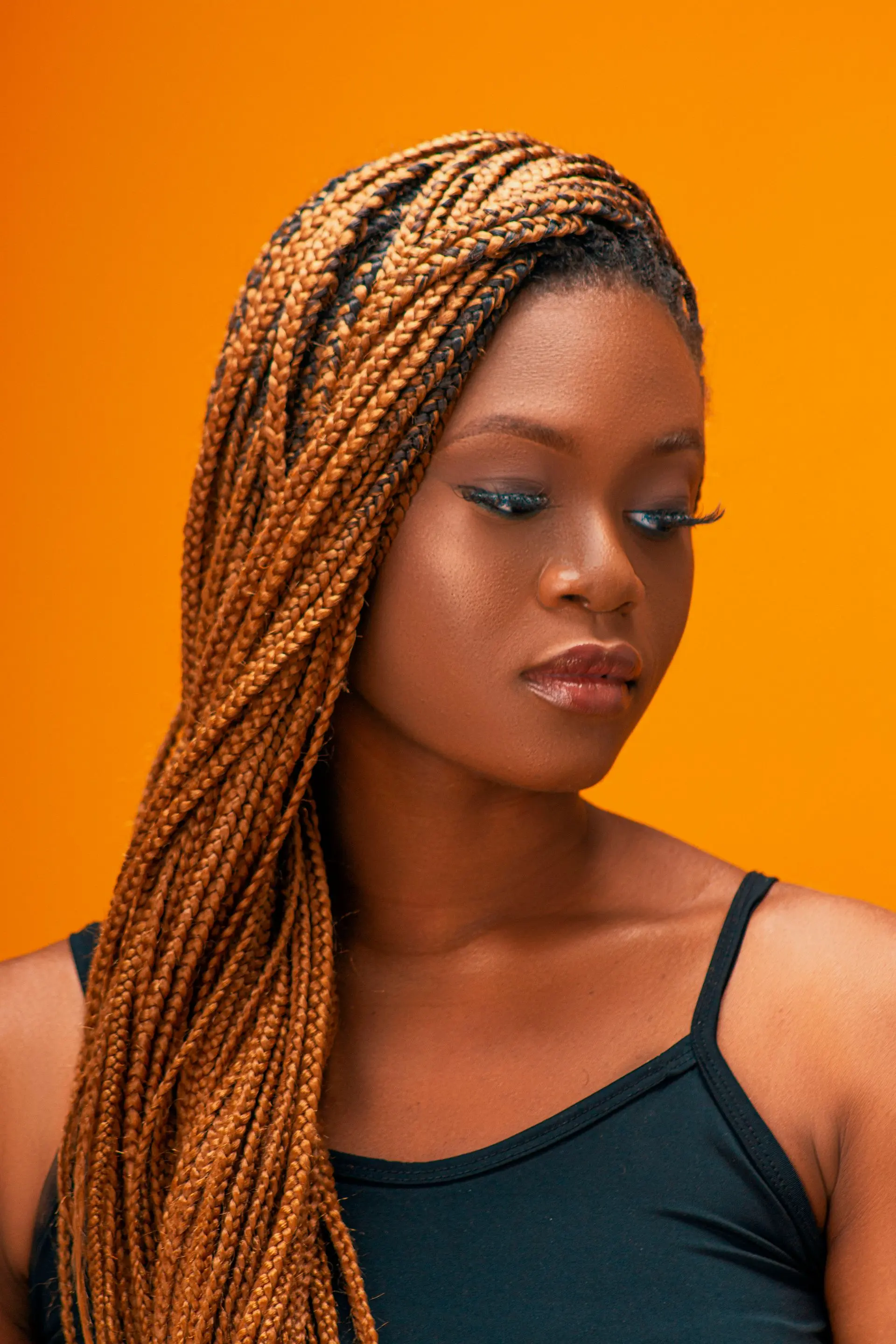Editorial portrait of box braids, vivid honey-toned hair artistry