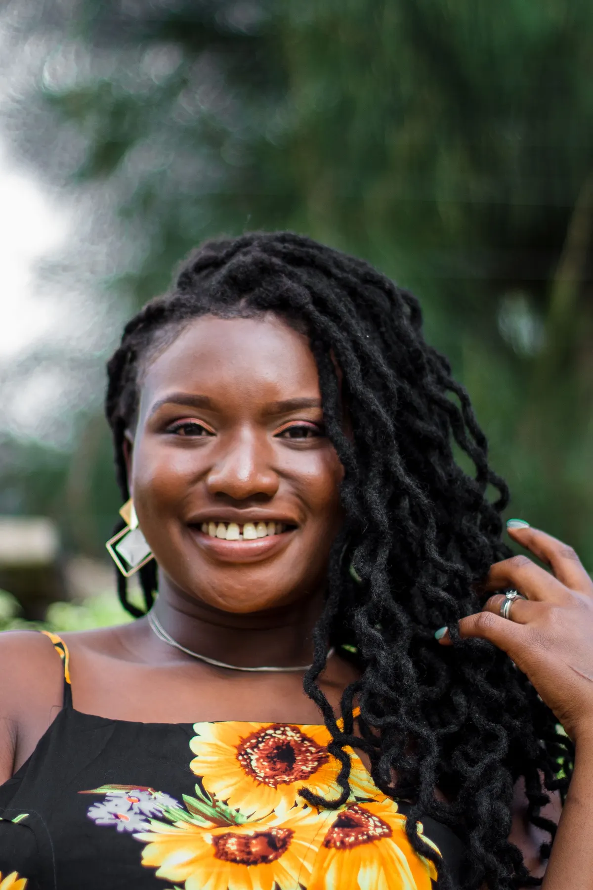 Client smiling with finished locs and gold earrings